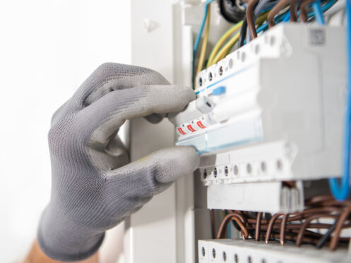 Electrician Testing Fuses In the Electric Box